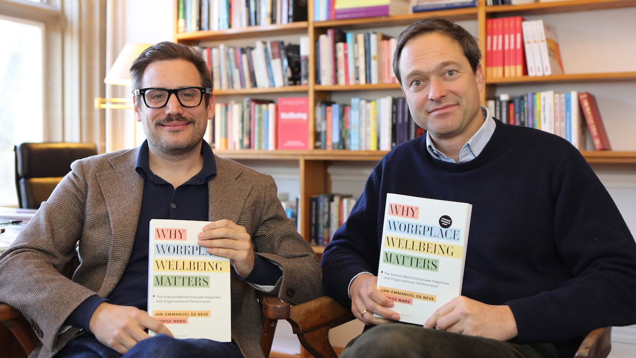 Jan-Emmanuel De Neve and George Ward with their book Why Workplace Wellbeing Matters.